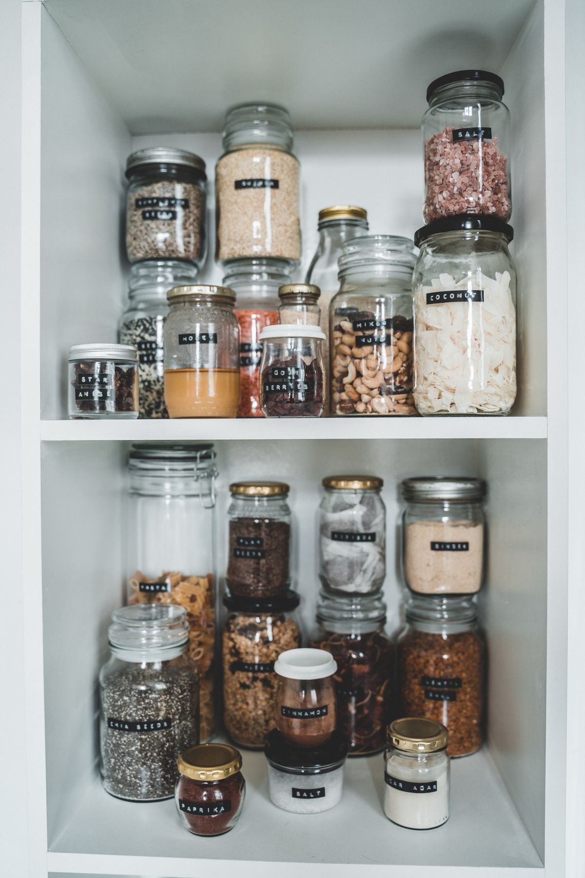 Clear glass spice jars neatly organized on shelf